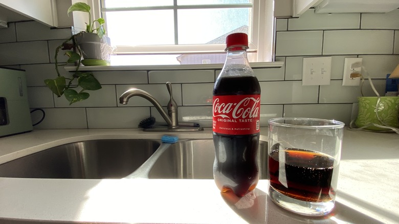 Coke bottle by kitchen sink