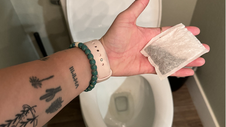 Adding tea bag to toilet