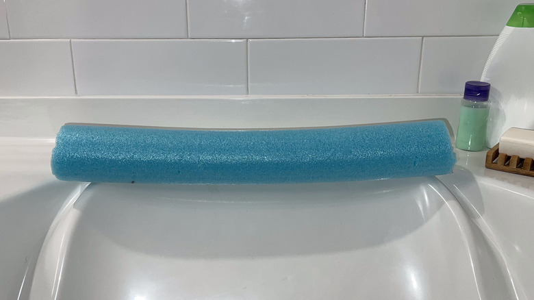 blue noodle headrest in bathtub