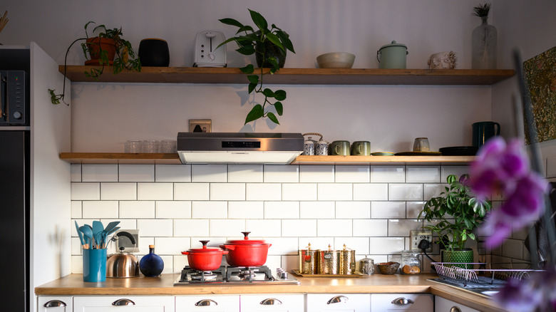 a bright kitchen with colorful florals and pots on display