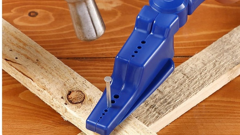 Hammering a nail in using nail holding pliers to keep it safe