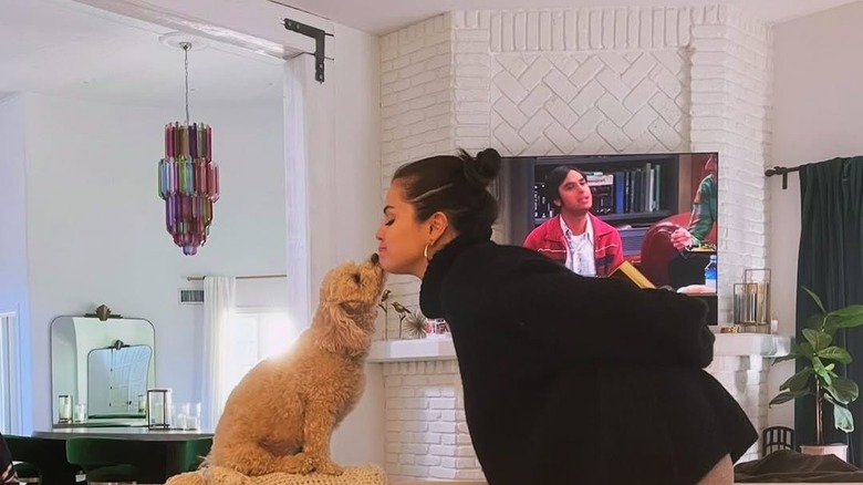 Selena Gomez kissing a dog in her home.