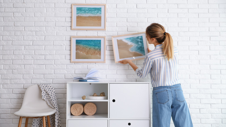 woman hanging photos