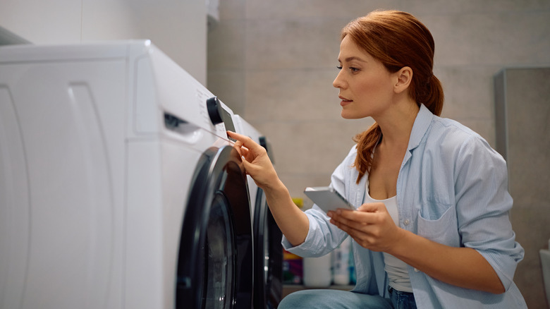Woman starting washing machine