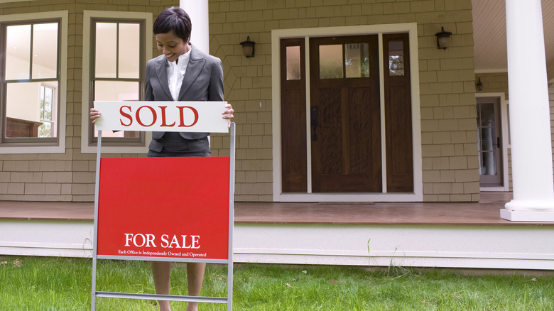 realtor with home sold sign