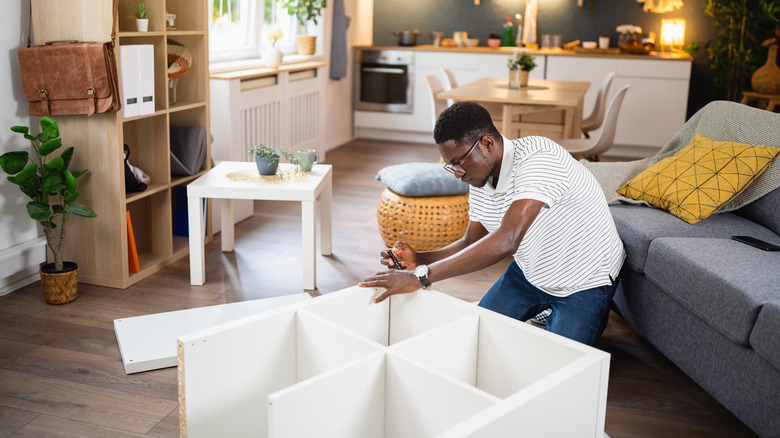 man building ikea shelf