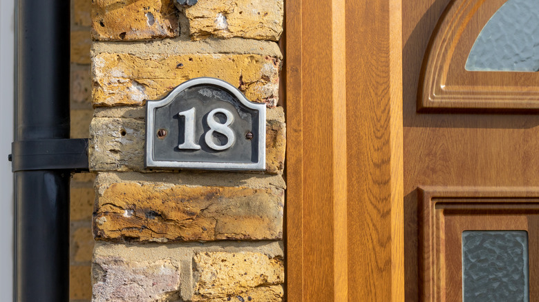 Address plaque beside wood door