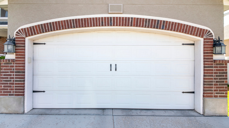 A carriage-style garage door with faux hardware