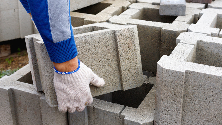 Someone working on a project with cinder blocks