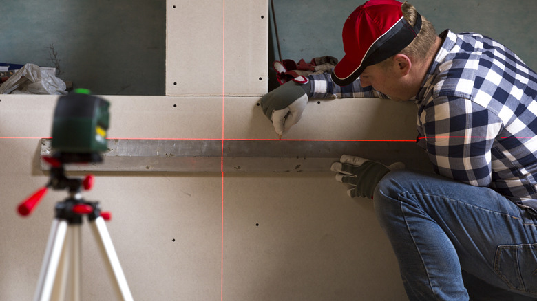 Man uses laser to level wall