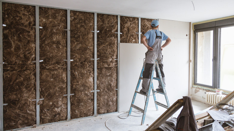 Man studies drywall installation
