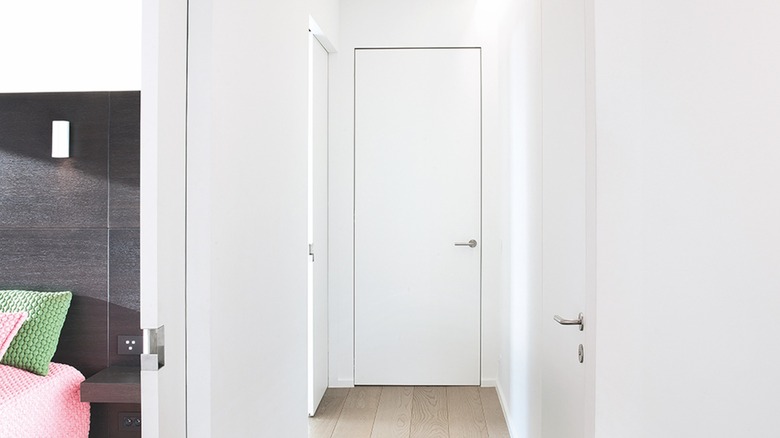White frameless door at the end of hallway