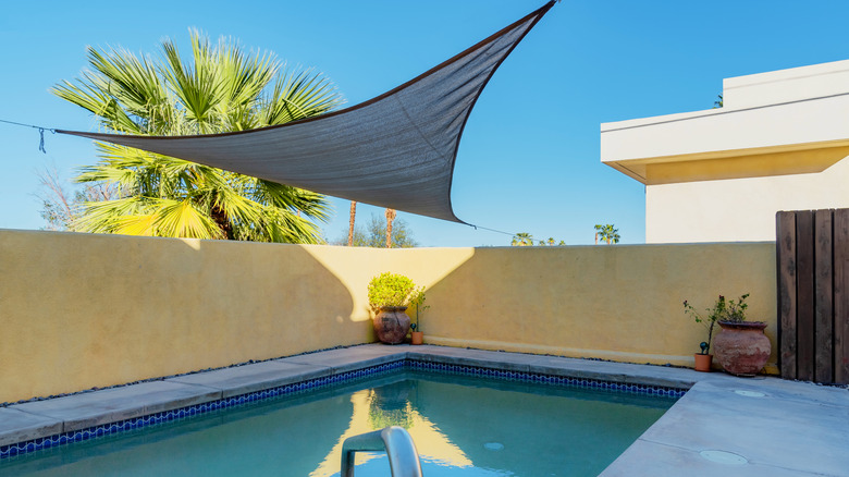 Shade sail over a swimming pool.