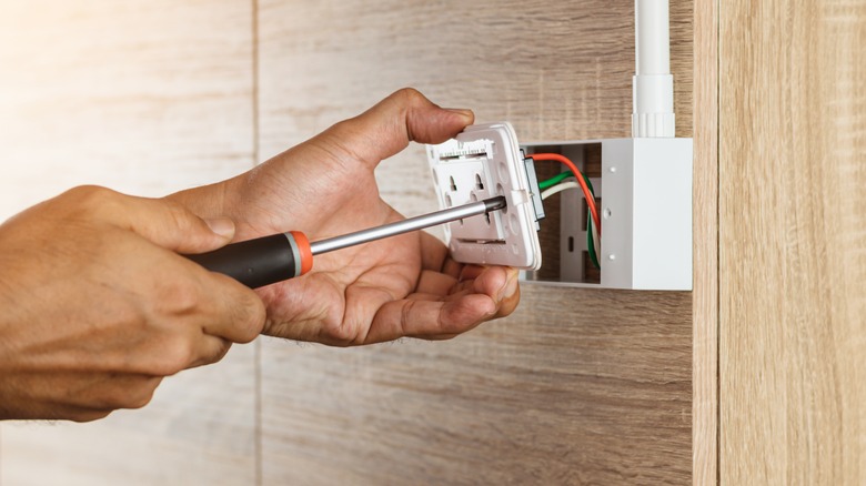 electrician repairing outlet