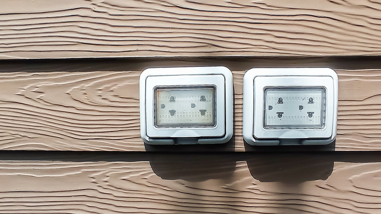 Two outdoor electrical outlets with covers in place
