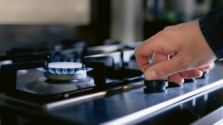 Person turning on a gas stove burner