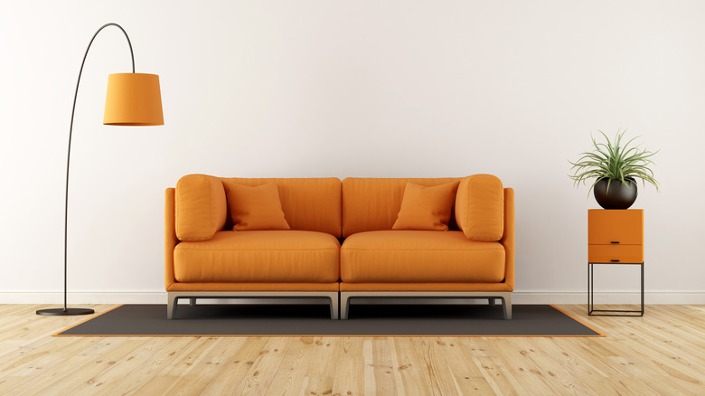 Orange couch in white living room