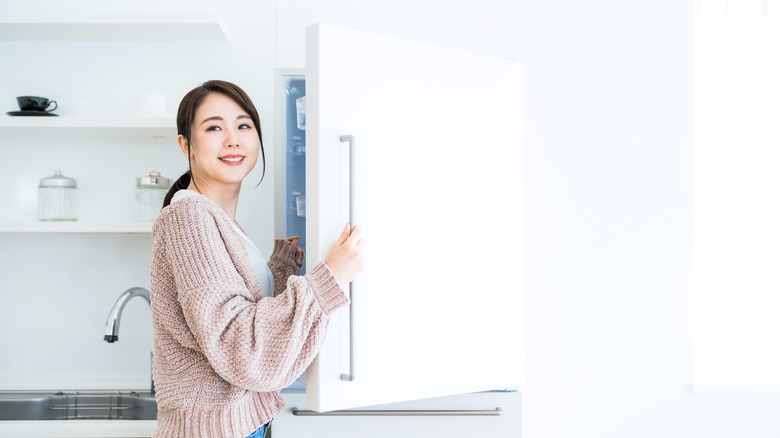 woman opening fridge