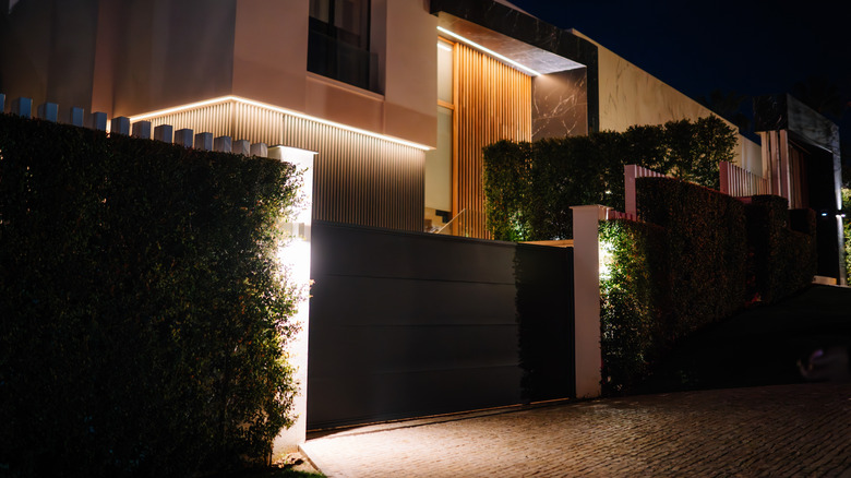 The exterior of a home with outdoor lighting and a security gate
