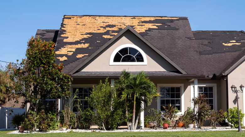 House with missing shingles after a storm.