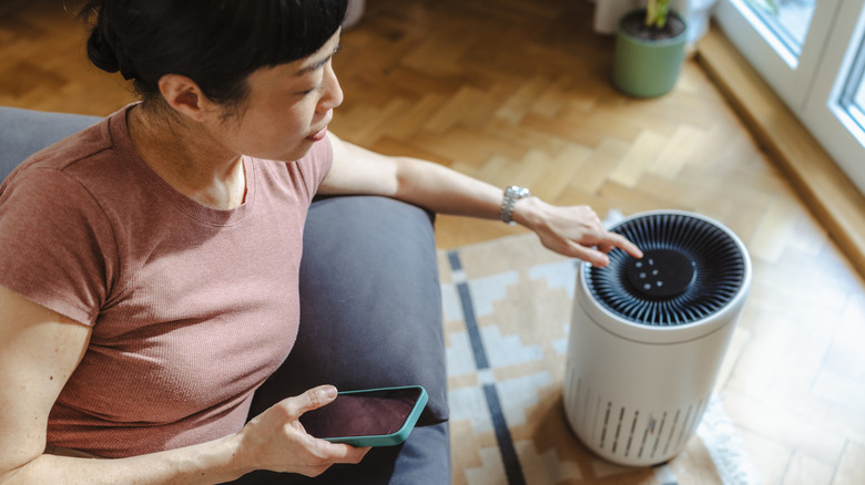 woman adjusting air purifier