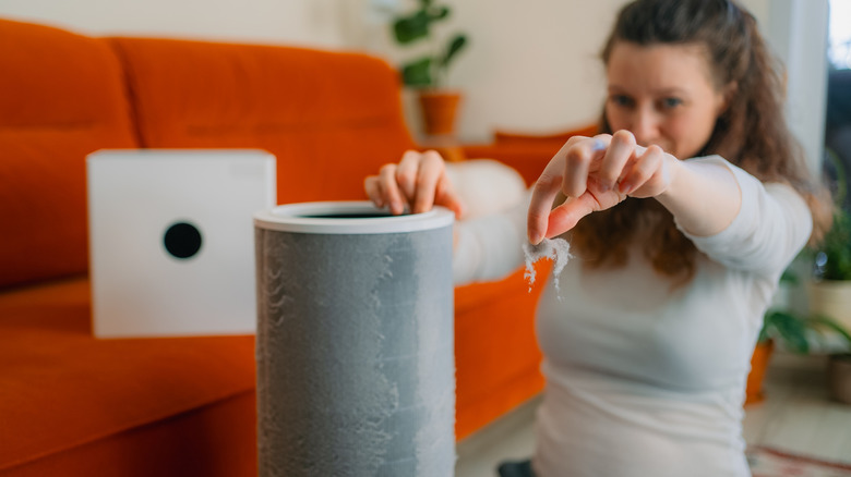 woman changing dirty air filter