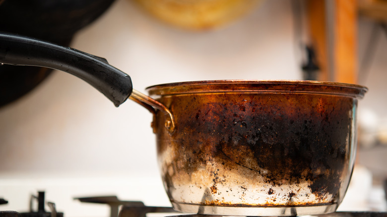 Pot that is badly charred on top of gas stove.