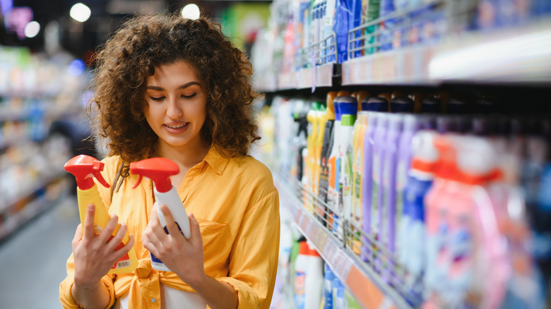 A woman holding cleaning products in a store