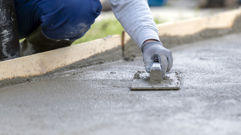construction worker finishing concrete with a trowel and plasterer