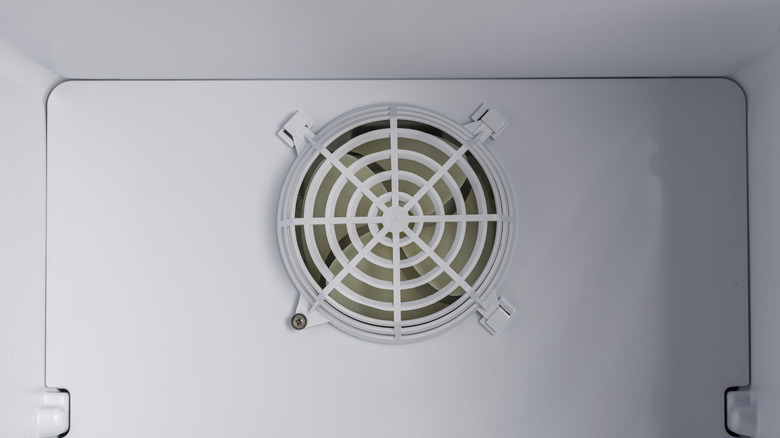 Closeup of round freezer fan behind protective grille