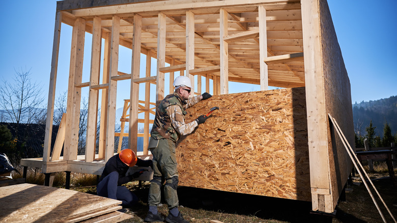 Two construction workers framing a house