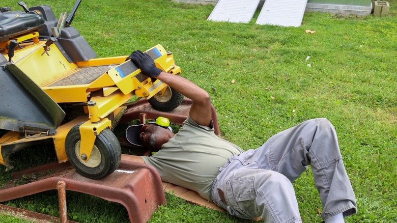 Man trying to fix lawn mower