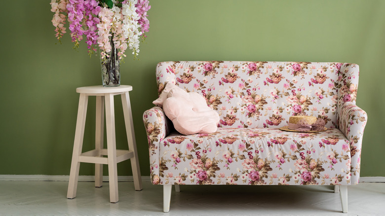 floral couch against green wall