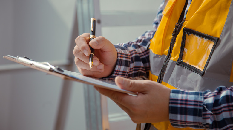 Contractor writing on documents