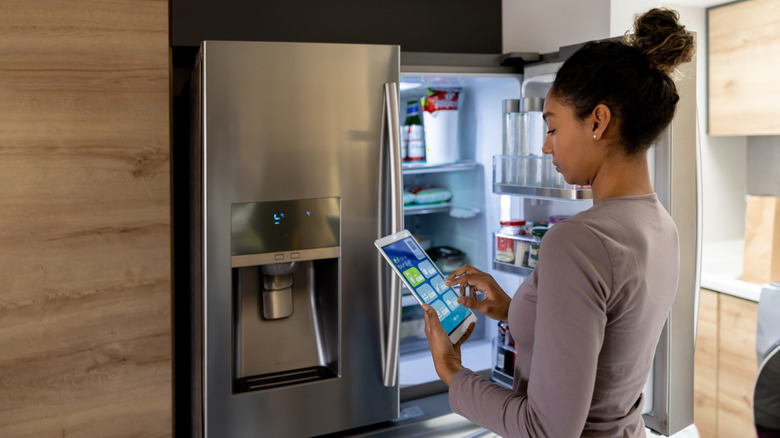 Person uses tablet to put fridge in vacation mode
