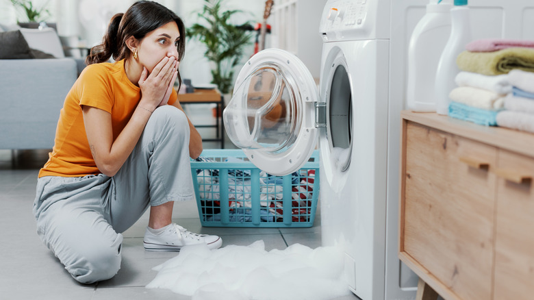 Woman next to overflowing washer