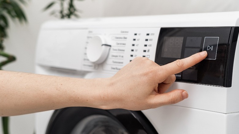 Closeup of hand pointing to washer setting
