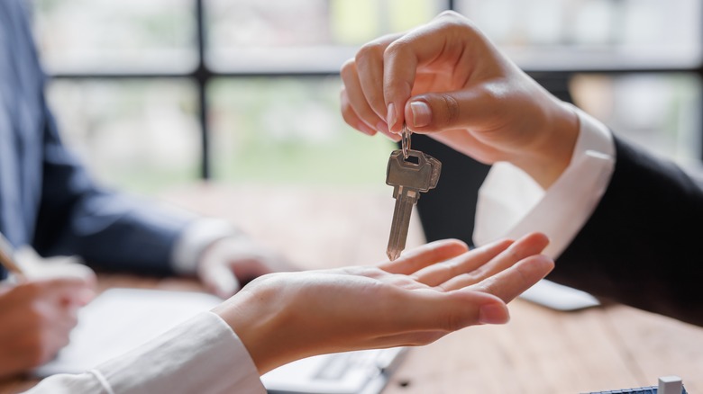 Businesswoman handing woman two keys