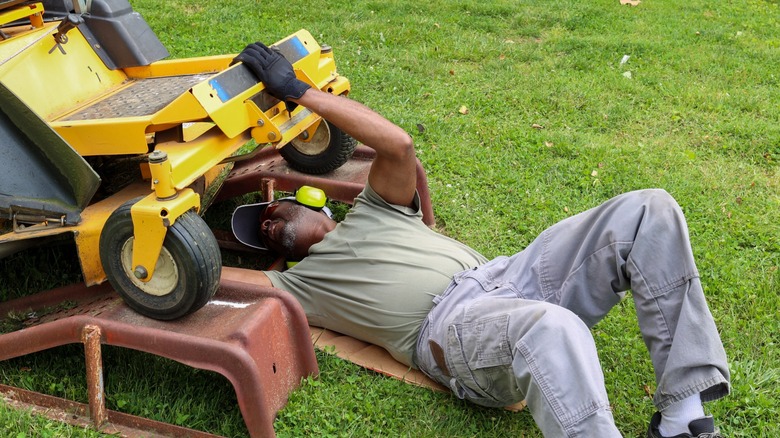 Man repairing lawn mower