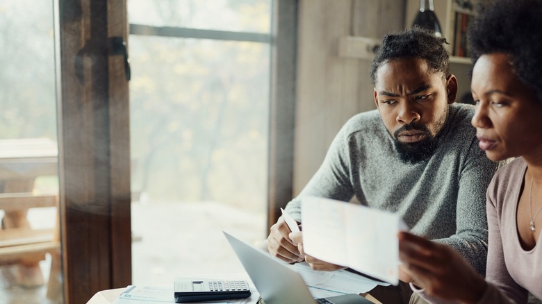 Couple looking worried about finances 
