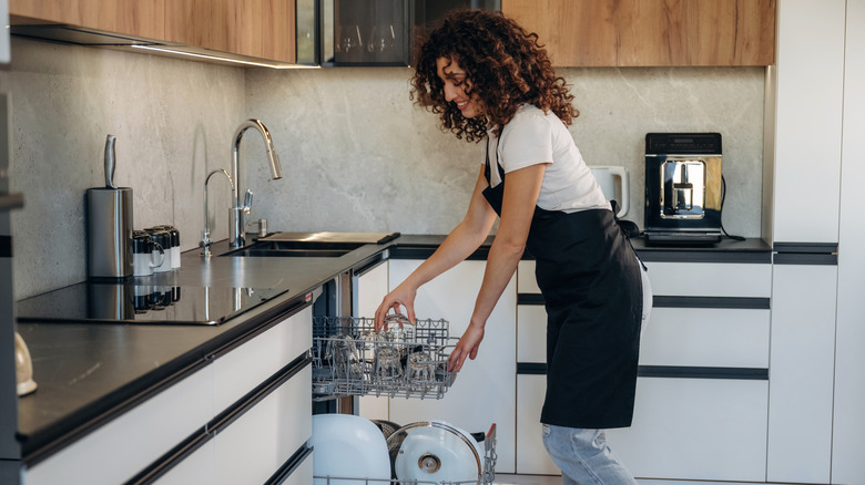 A woman loading the dishwasher.