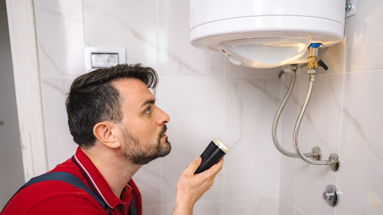Man inspecting a water heater