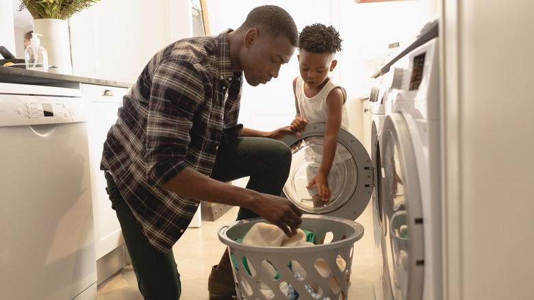 father and son doing laundry 