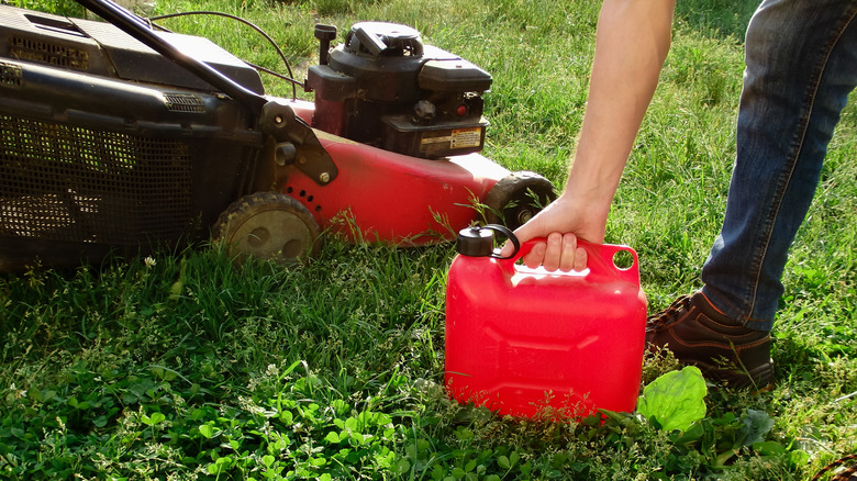 Person adding gasoline to a lawn mower
