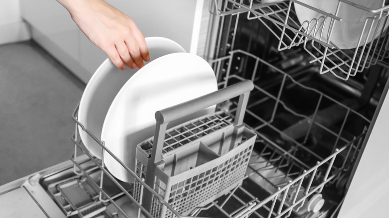 woman loading dishwasher half full 