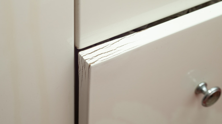 Paint cracking and wood warping on a drawer