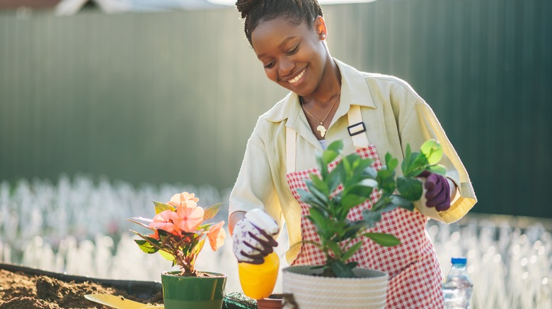 Woman tending to flower pots 