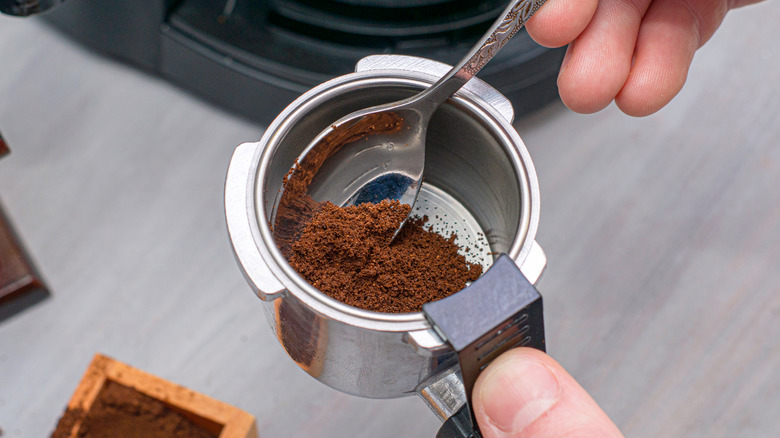 person preparing to add coffee grounds