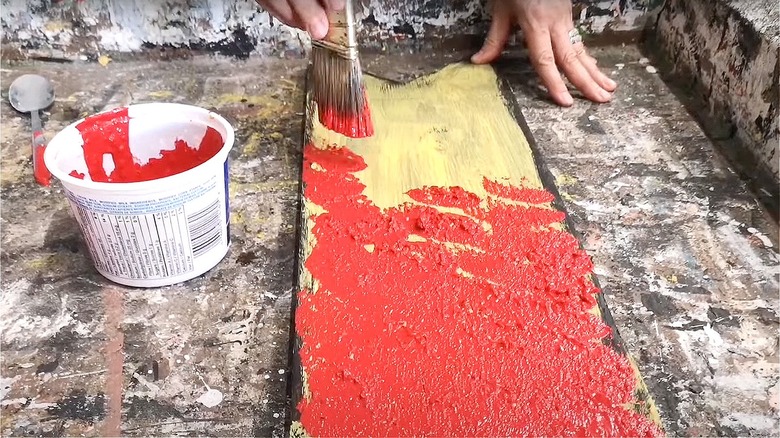 Person applying red salt paint