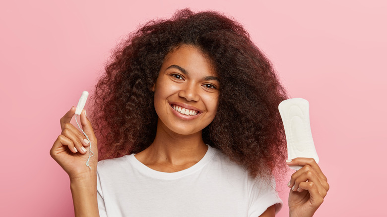 woman holding tampon and pad